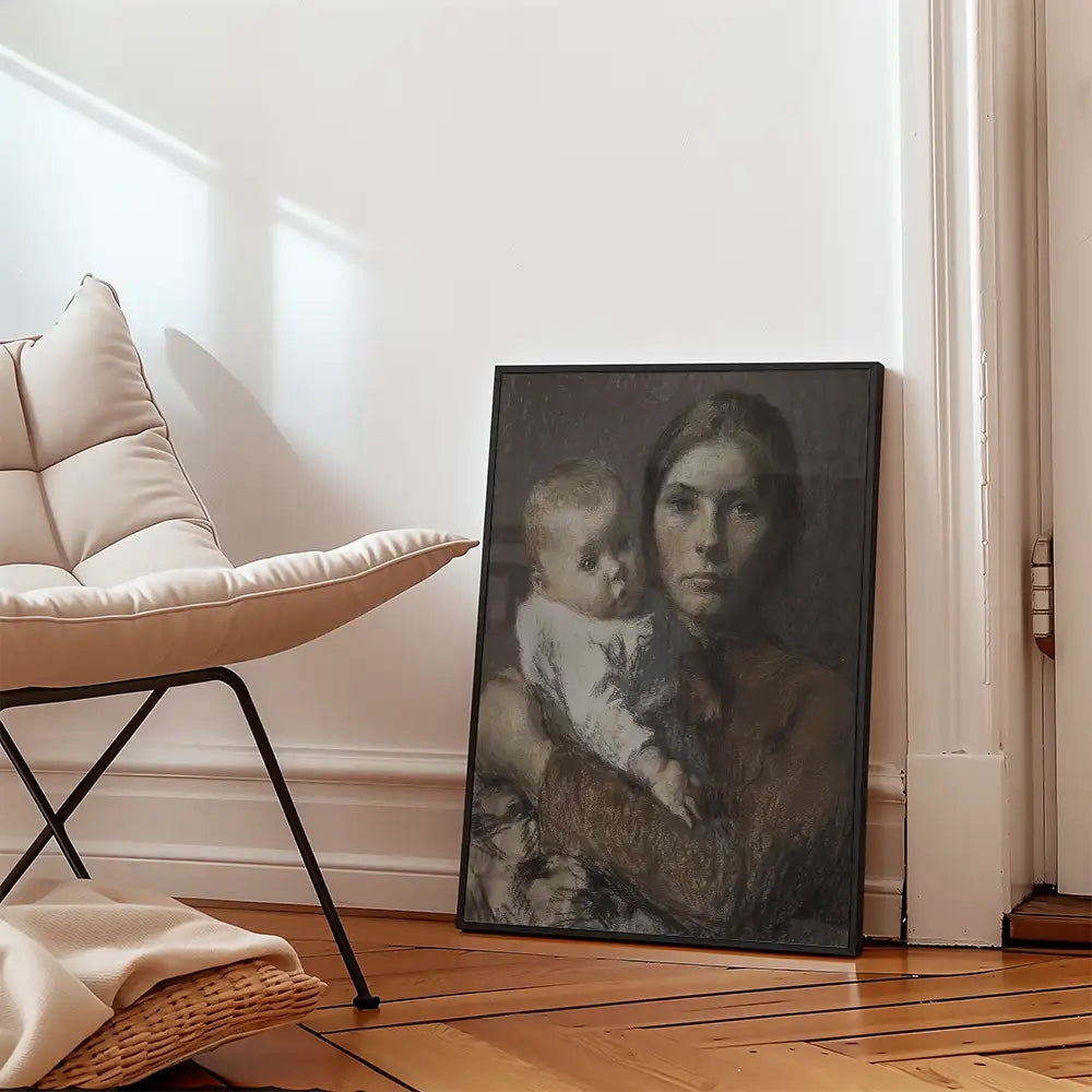Painting of a woman holding a baby, framed and leaning against a wall, with a modern chair and hardwood floor in the background.