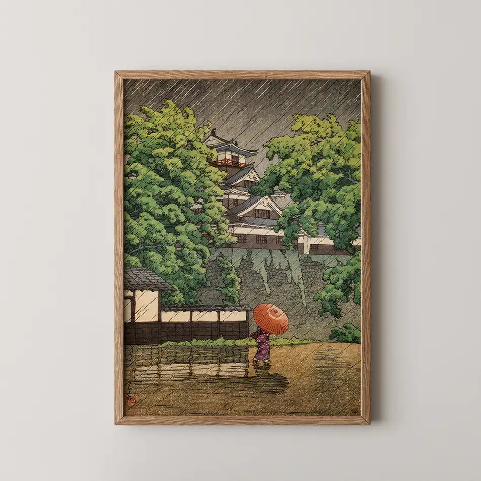 Framed artwork depicting a woman in a purple kimono walking with an umbrella in a rainy landscape featuring lush greenery and traditional architecture.