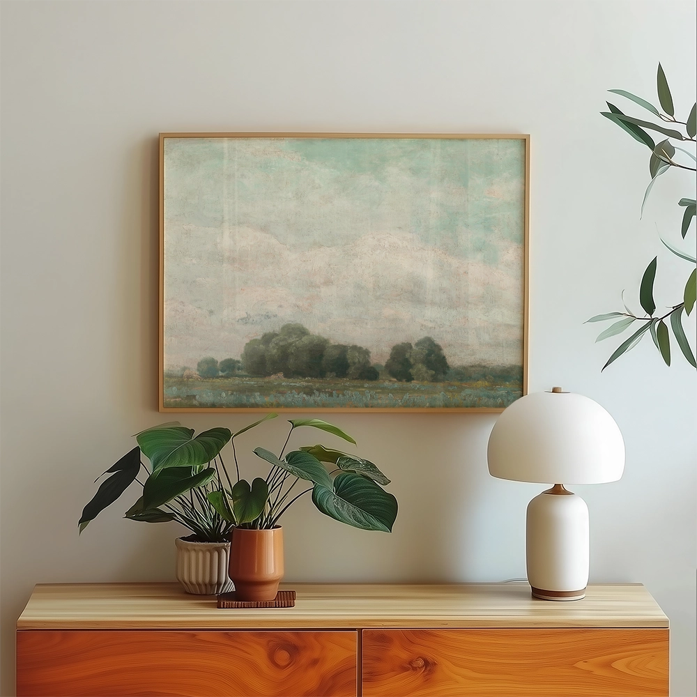 Abstract landscape painting in a wooden frame, displayed on a wall above a stylish wooden cabinet with a potted plant and a decorative lamp.