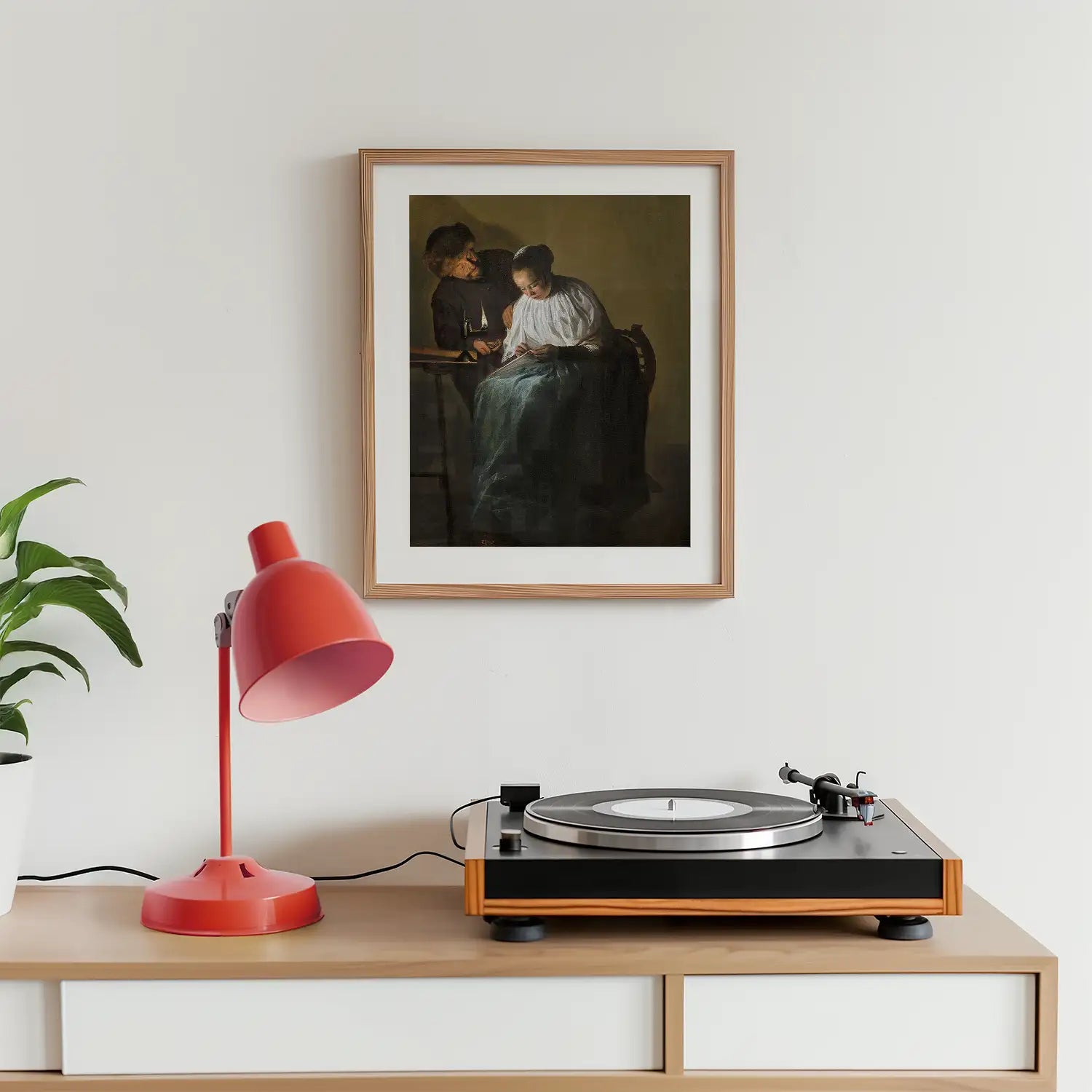 Painting of two women in a framed artwork above a retro turntable and a red desk lamp in a modern interior setting.