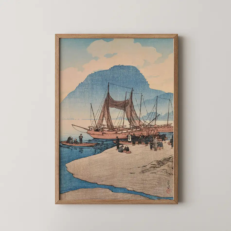 Framed painting of a tranquil scene featuring traditional boats on a beach with distant mountains under a pastel sky.