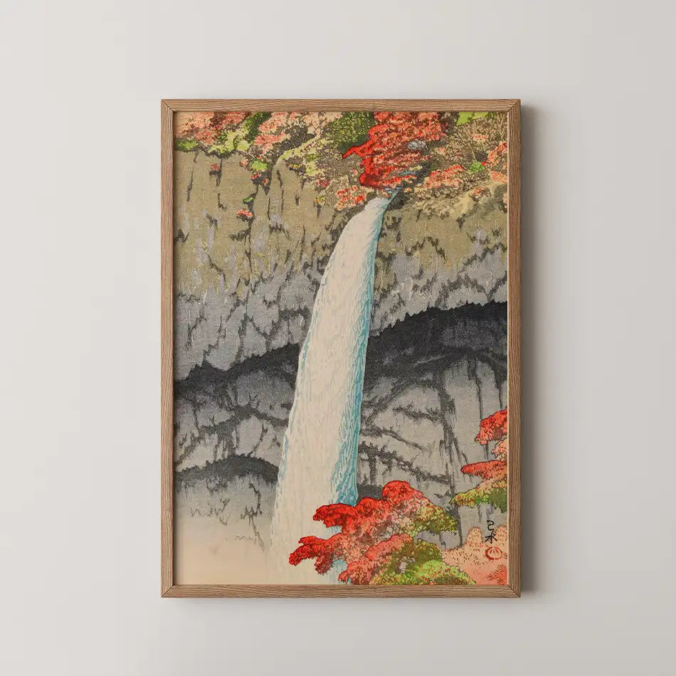 Framed painting of a waterfall surrounded by vibrant red foliage and rocky cliffs.