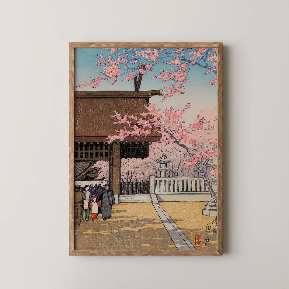 Framed painting of a tranquil scene with cherry blossoms and people walking near a traditional building.