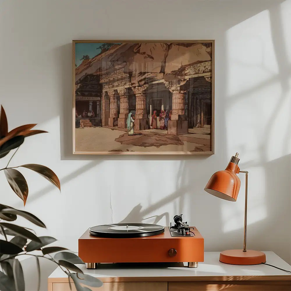 Painting of an ancient architectural site featuring figures in traditional attire, framed and displayed above a record player and lamp in a modern interior setting.