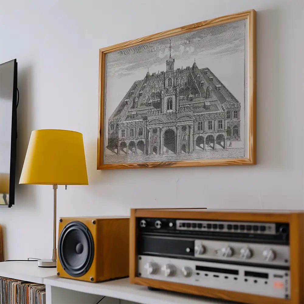 Framed black and white architectural print of a historic building, displayed on a wall with a yellow lamp and audio equipment nearby.