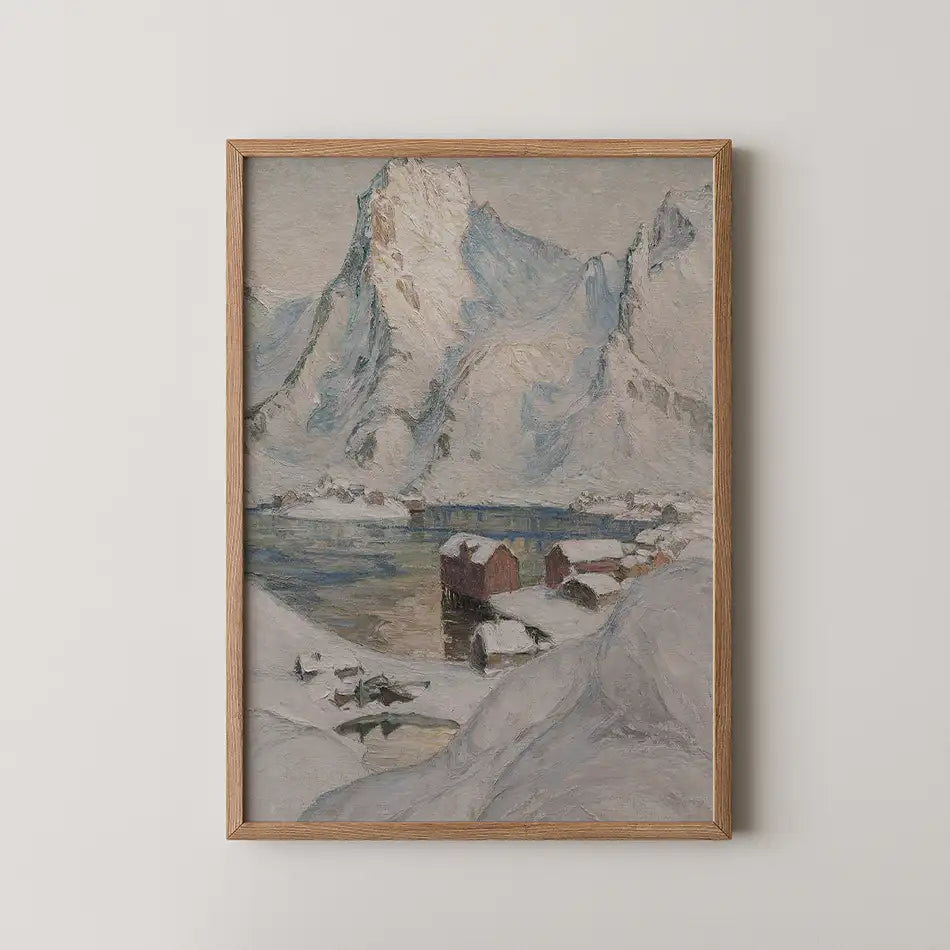 Framed painting of a snowy mountain landscape with a calm lake and small wooden houses.