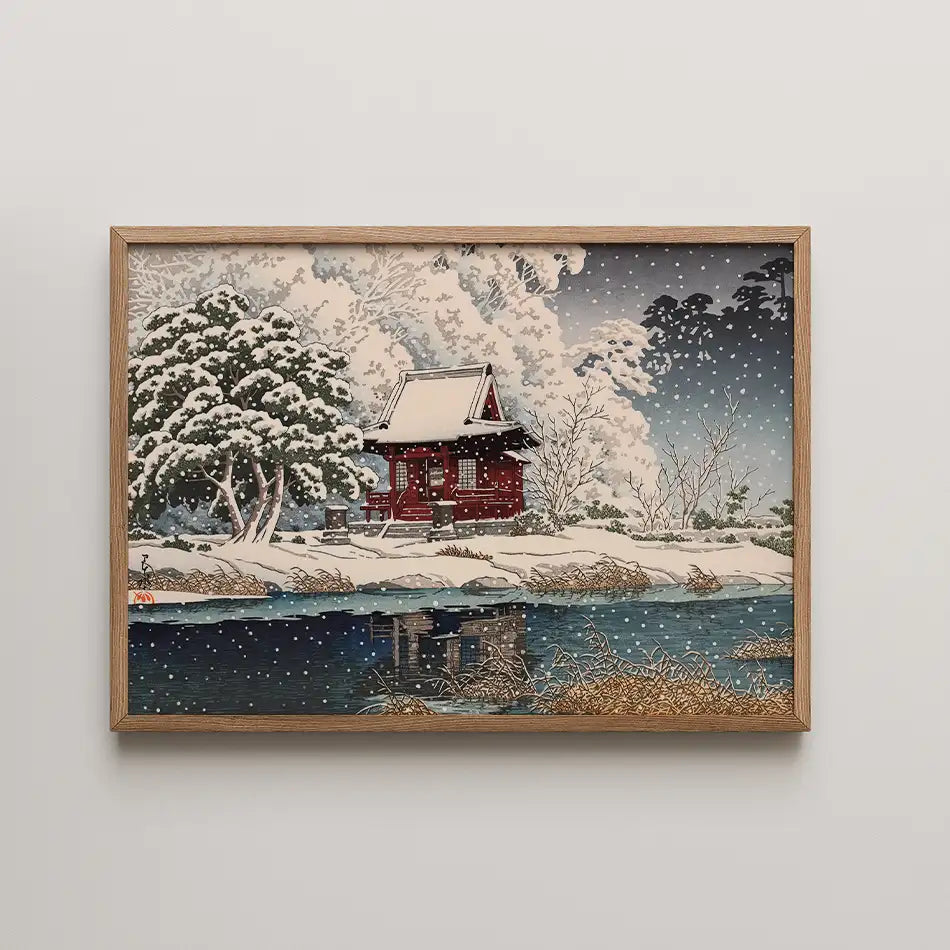 Framed painting of a traditional Japanese house surrounded by snow-covered trees and a river reflecting the scene.