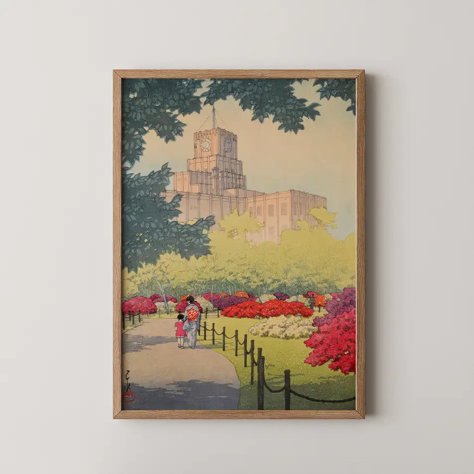 Framed painting of a park scene featuring vibrant flowers and a couple walking along a path with a historic building in the background.