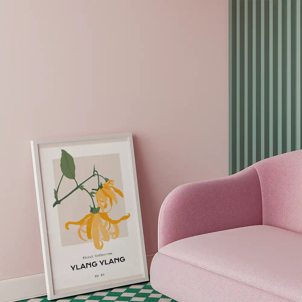 Modern Ylang Ylang flower poster in a white frame, styled in a contemporary living room with pastel pink walls and a pink couch.