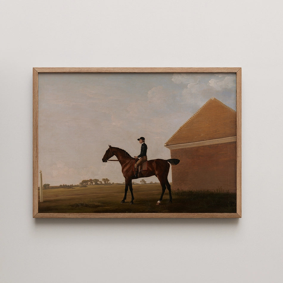 Framed painting of a horse and rider in a landscape with a building in the background.