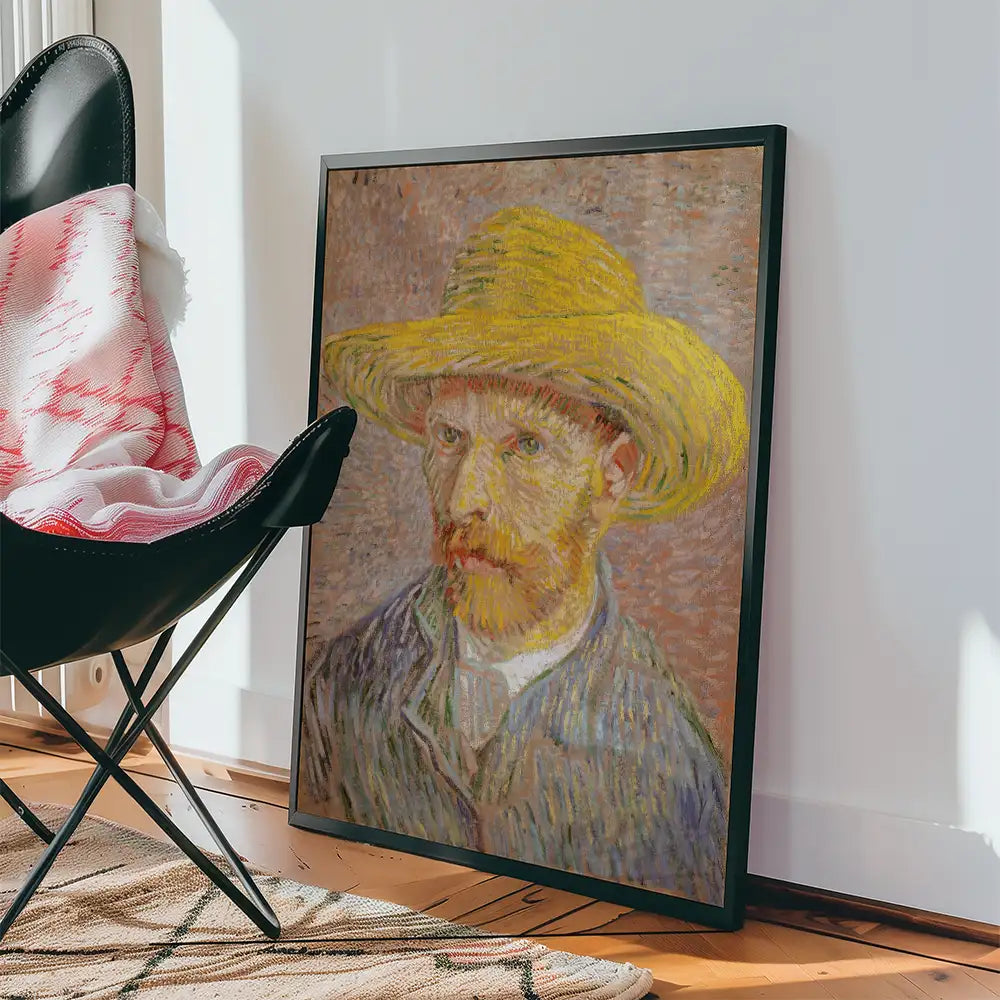 Framed painting of a man in a straw hat, displayed beside a black chair and a cozy blanket.