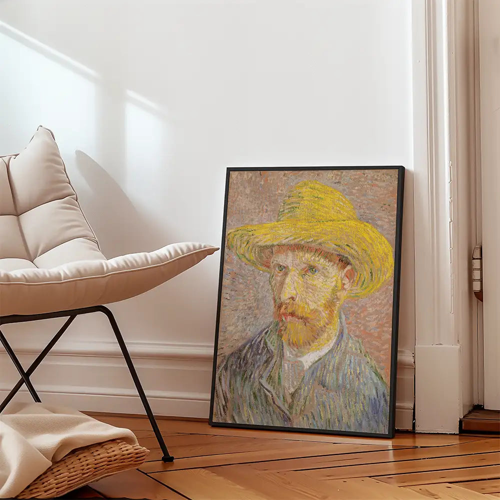 Framed painting of a man with a straw hat, displayed beside a modern chair in a bright interior setting.