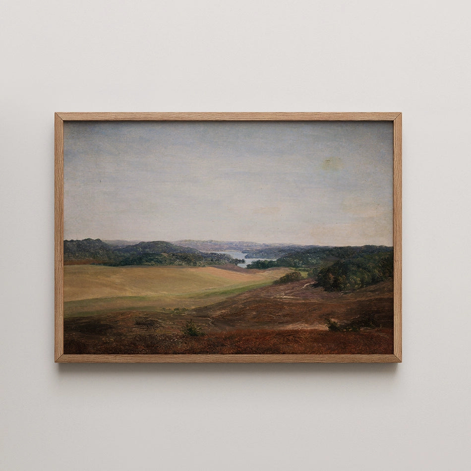 Framed landscape painting featuring rolling hills and a river under a serene sky.