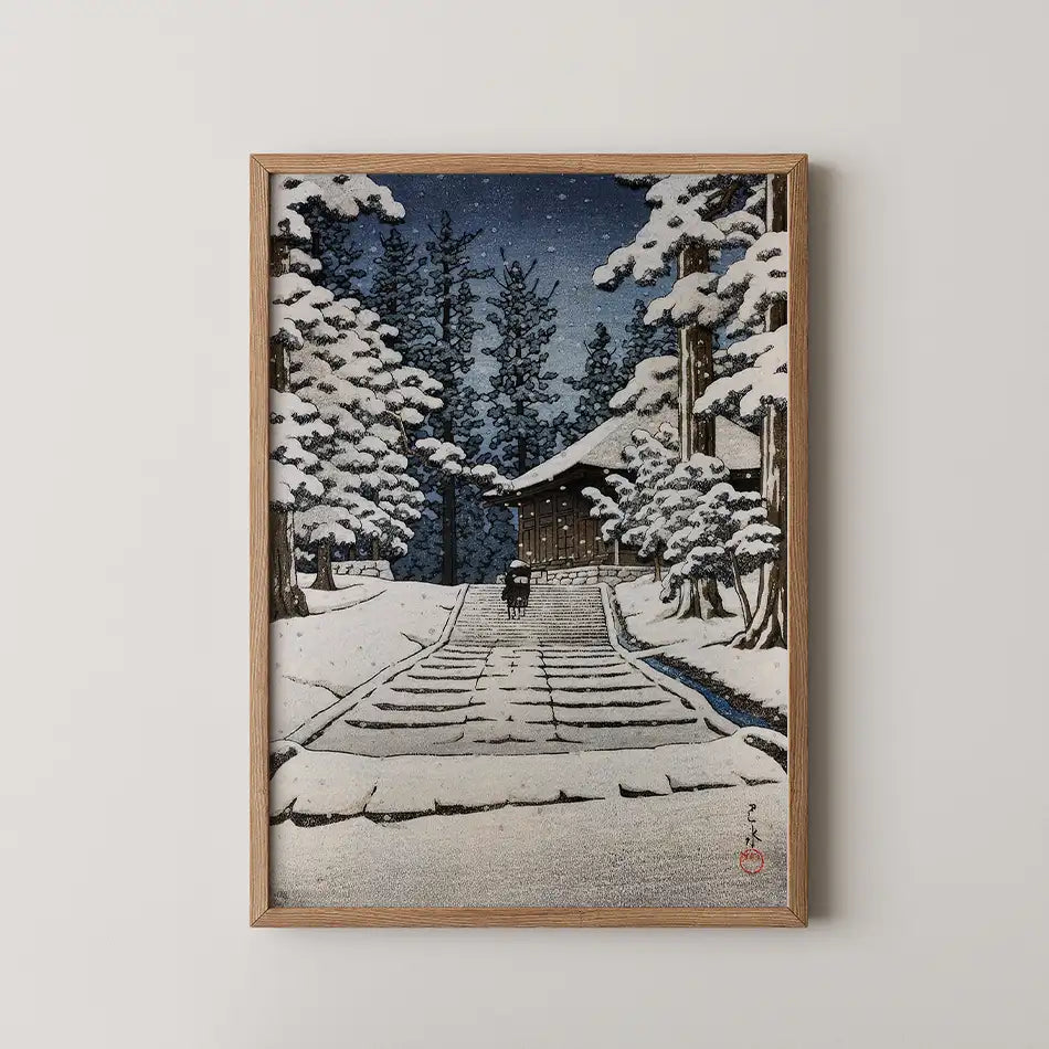 Framed painting of a winter landscape featuring a chapel surrounded by snow-covered trees and a person walking on a path.