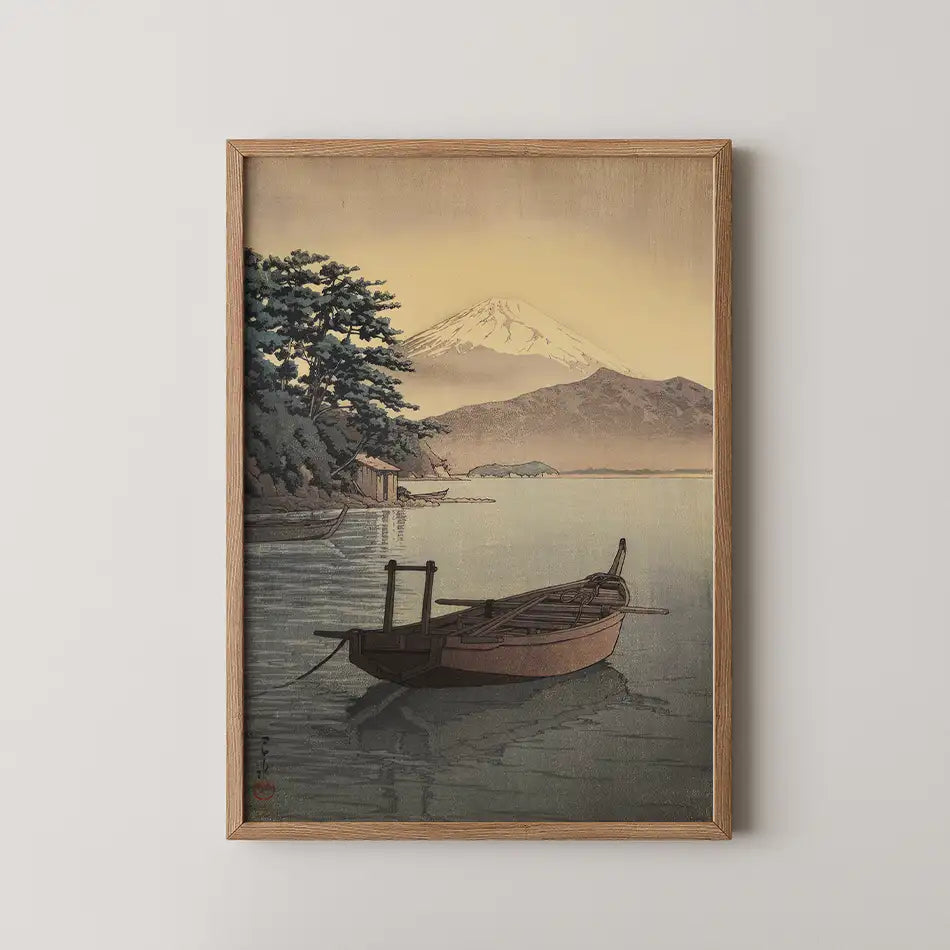 Painting of a serene landscape featuring a small boat on still water with a mountain in the background, framed in wood.