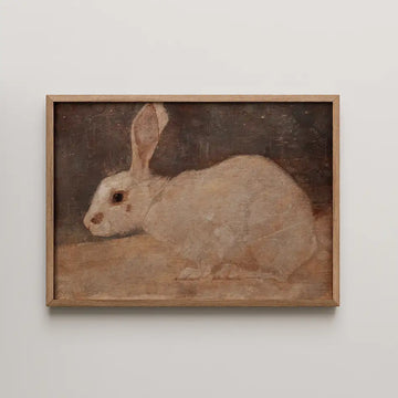 Painting of a white rabbit displayed in a wooden frame.