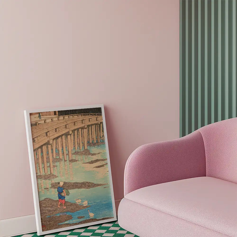 Child standing on a shore feeding ducks, with a wooden pier in the background, framed painting leaning against a pink sofa in a stylish interior.