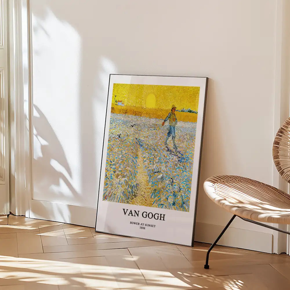 A framed print of Van Gogh's "Sower at Sunset" leaning against a wall, with a modern chair in the foreground.