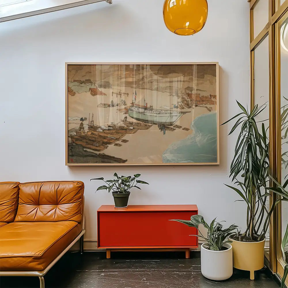 Framed painting of boats at a shore, displayed above a modern orange sofa and red cabinet in a chic interior setting with plants.