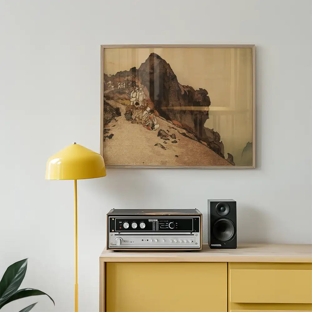 Framed painting of a mountain scene hanging above a yellow lamp and audio equipment on a wooden cabinet.