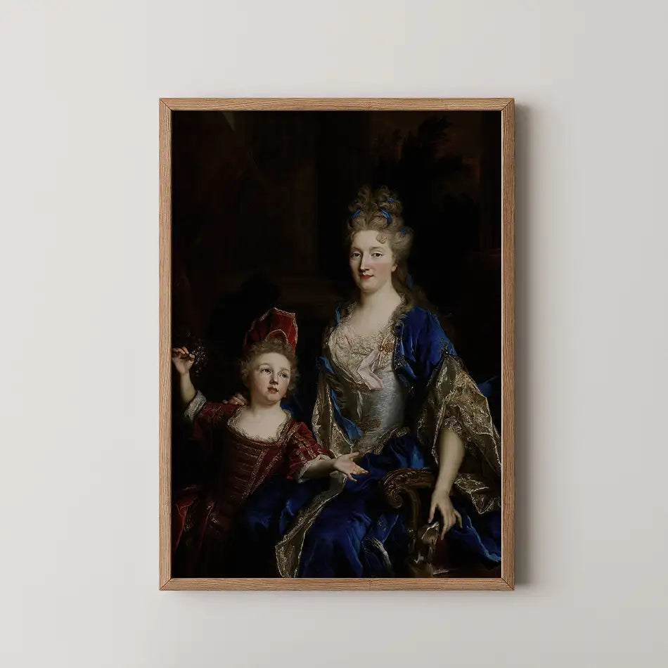 Painting of a woman in a blue gown seated beside a child in a red outfit, framed in a wooden frame, on a light wall.