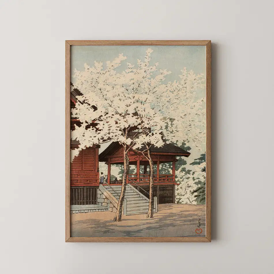 Framed painting featuring a serene landscape with cherry blossom trees and traditional architecture.