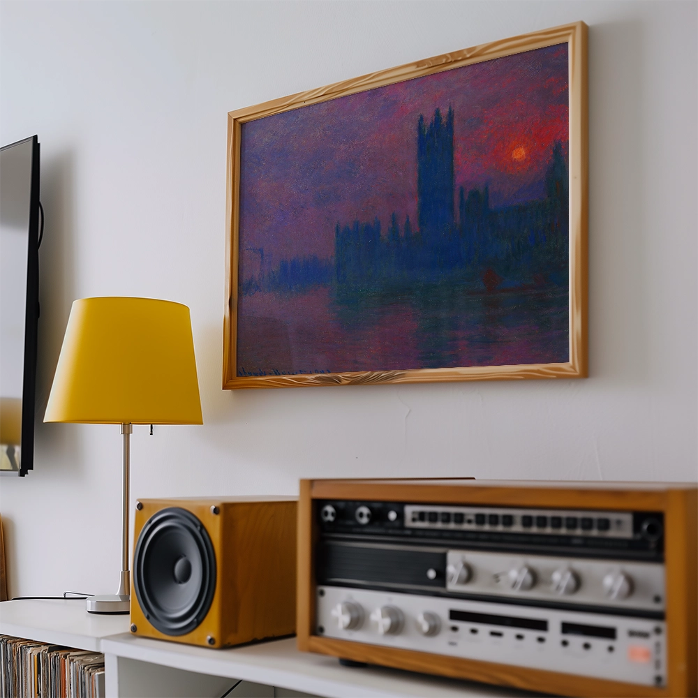 Painting of a silhouetted skyline with a colorful sunset, framed above a modern lamp and vintage audio equipment.