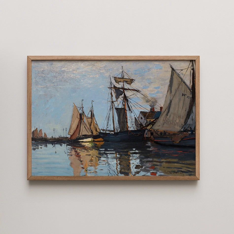 Painting of sailing ships in a harbor with reflections on the water, framed in light wood.