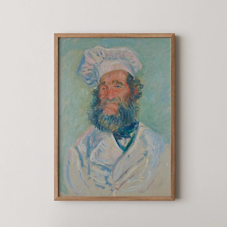 Portrait of a smiling chef with a thick beard, wearing a white chef's hat and coat, framed in natural wood.