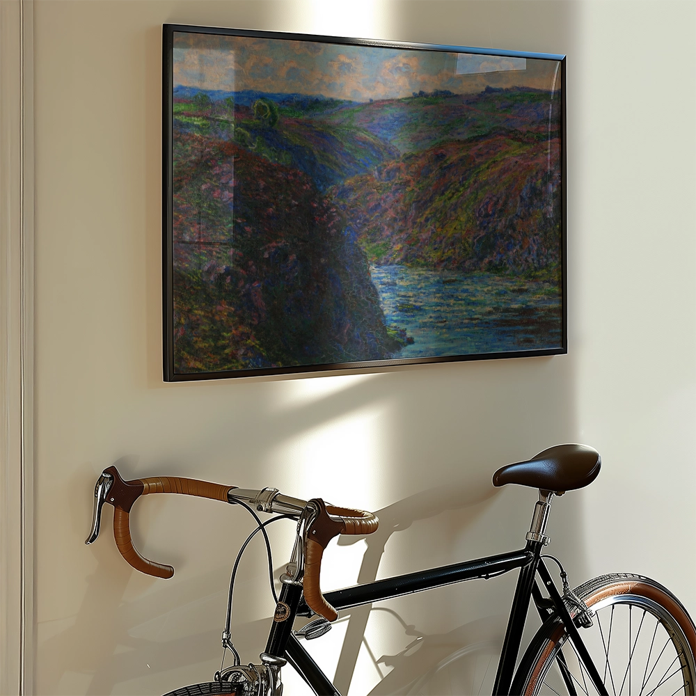 Framed painting of a lush landscape with a river, hanging on a wall next to a vintage bicycle.