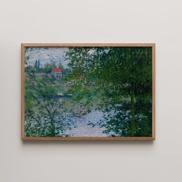 Painting of a tranquil landscape featuring a river, lush greenery, and a red-roofed house in the background, framed in light wood.