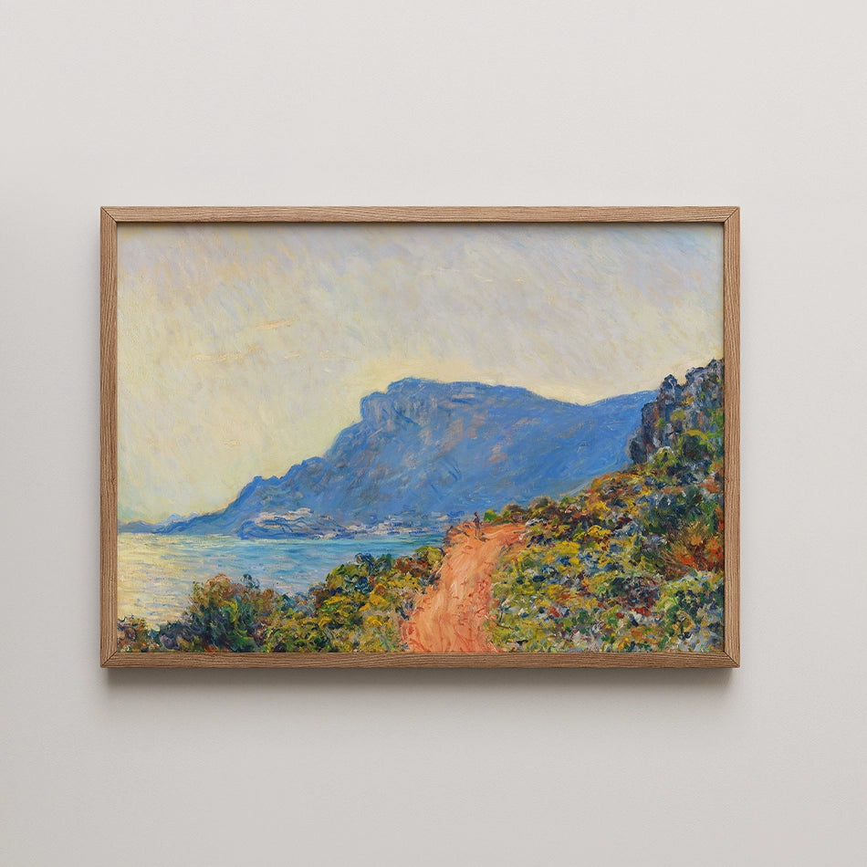Landscape painting of a coastal scene with a winding path, framed in natural wood.