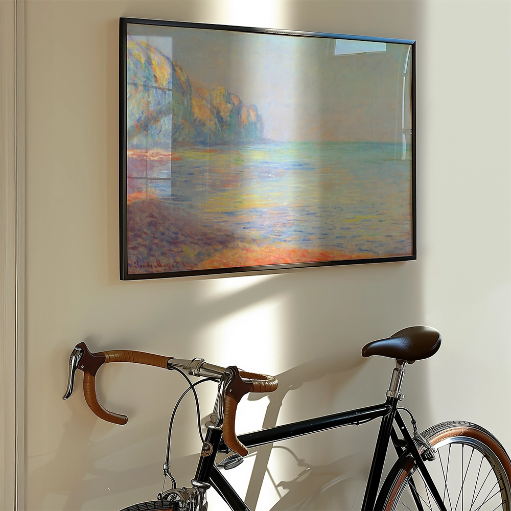 Painting of a colorful beach scene with cliffs, framed and hung on a wall next to a vintage bicycle.