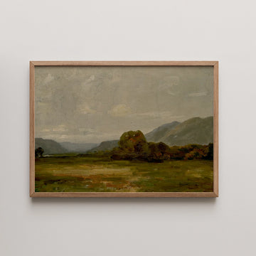 A framed landscape painting depicting rolling hills, a grassy field, and a cloudy sky.