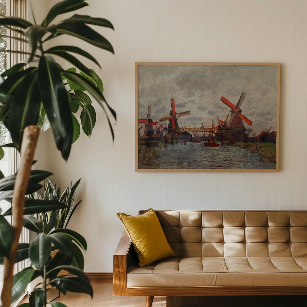 Painting of windmills in a frame, displayed above a brown sofa with a yellow pillow in a modern interior setting with plants.