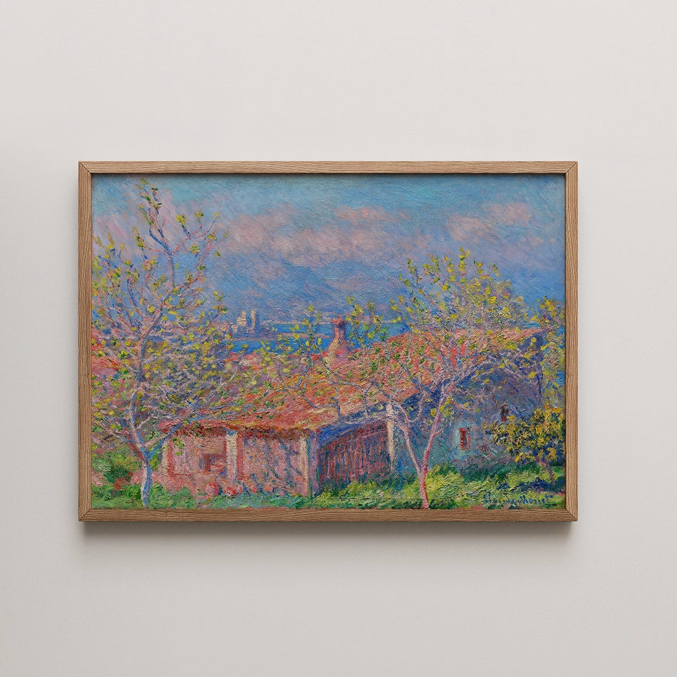 Framed painting of a rural landscape with blooming trees, a red-tiled roof, and a blue sky in the background.