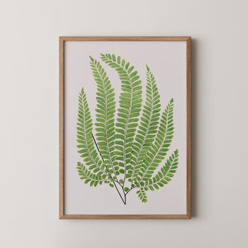 Framed artwork featuring a vibrant green fern illustration against a light background.