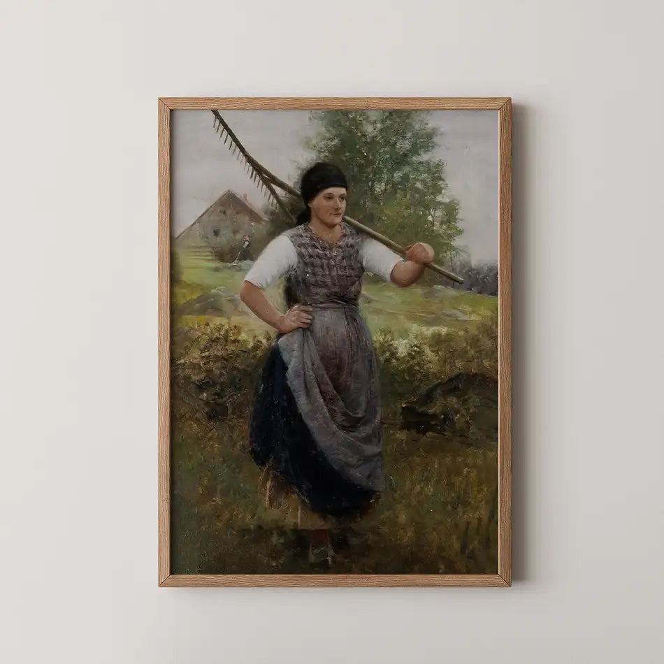 Painting of a woman holding a rake, standing in a grassy field with a farmhouse in the background, framed in light wood.