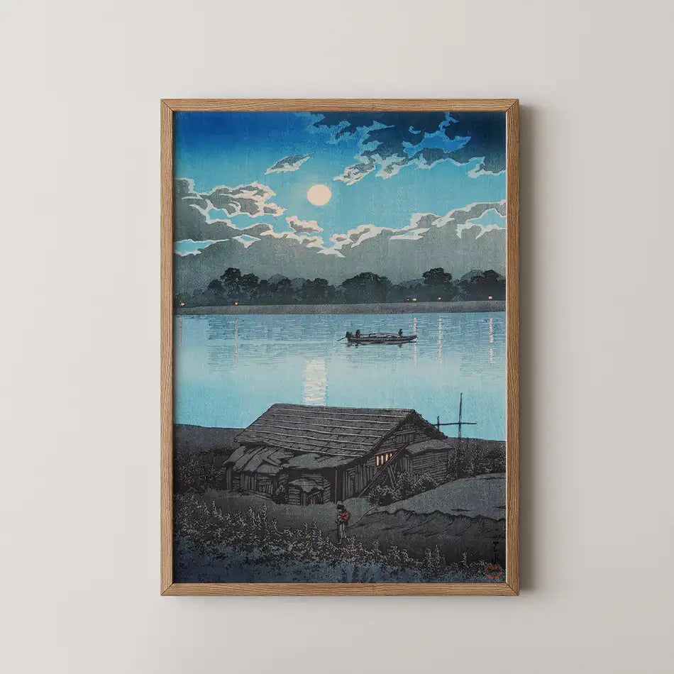 Framed painting of a serene lakeside scene at dusk, featuring a small house, a figure near the foreground, and a boat on the water under a moonlit sky.