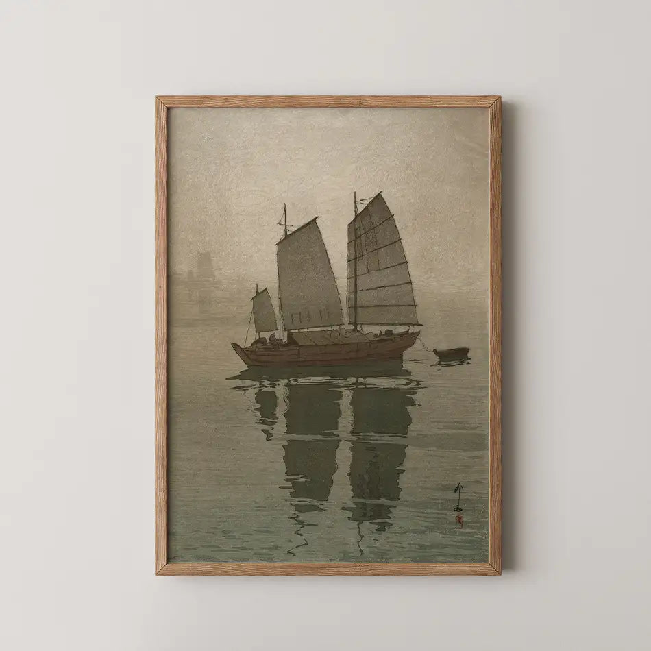 Framed painting of a boat with sails on water, reflecting its image, in muted tones.