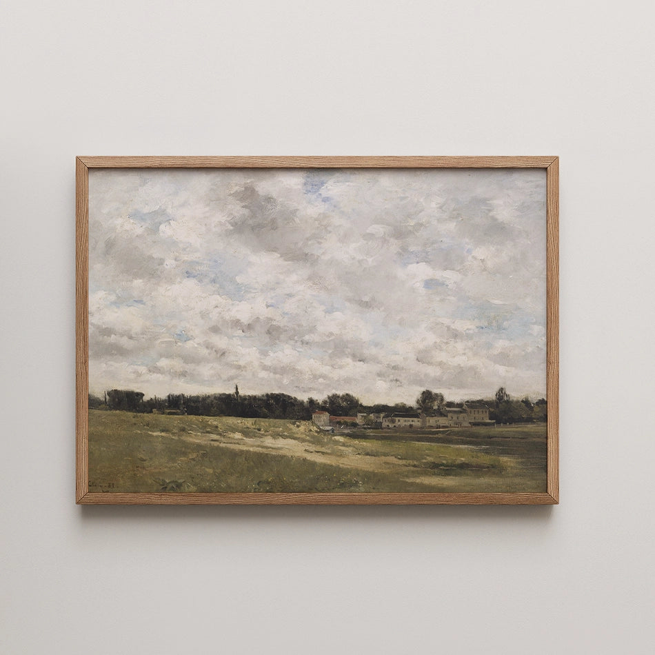 Landscape painting framed in wood, featuring a cloudy sky over green fields and distant buildings.