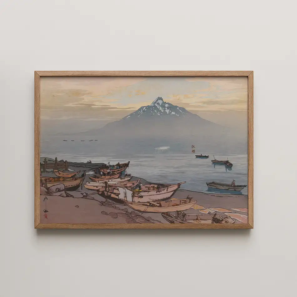 Framed painting of a serene coastal scene with boats on the shore and a mountain in the background during sunset.