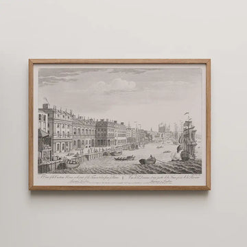 Framed black and white engraving of a waterfront scene featuring buildings, boats, and a ship in the harbor.