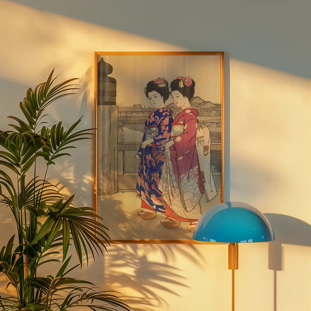 Framed painting of two traditional Japanese women in colorful kimonos, displayed on a wall with a nearby plant and stylish blue lamp.