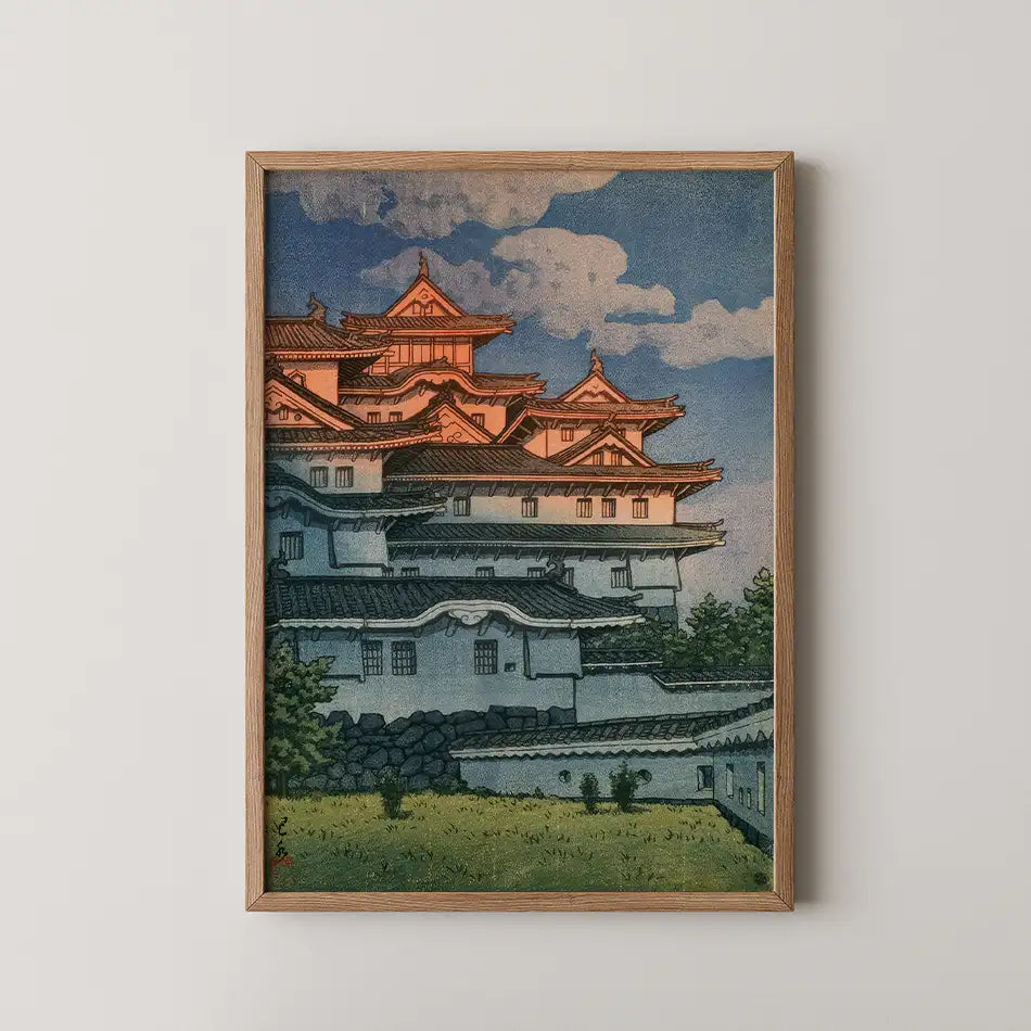 Framed painting of a traditional Japanese castle with red-tiled roofs and blue sky in the background.