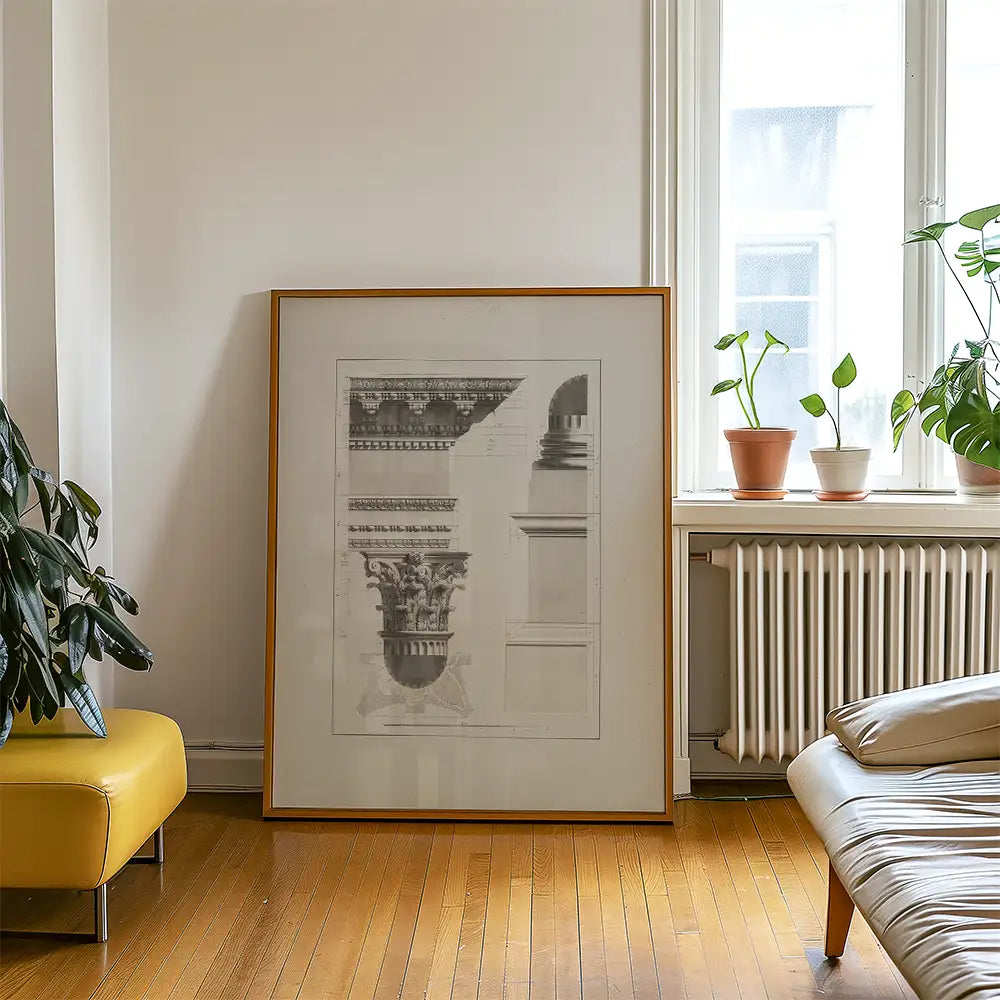 Framed architectural print leaning against a wall in a bright room with plants and a yellow chair.