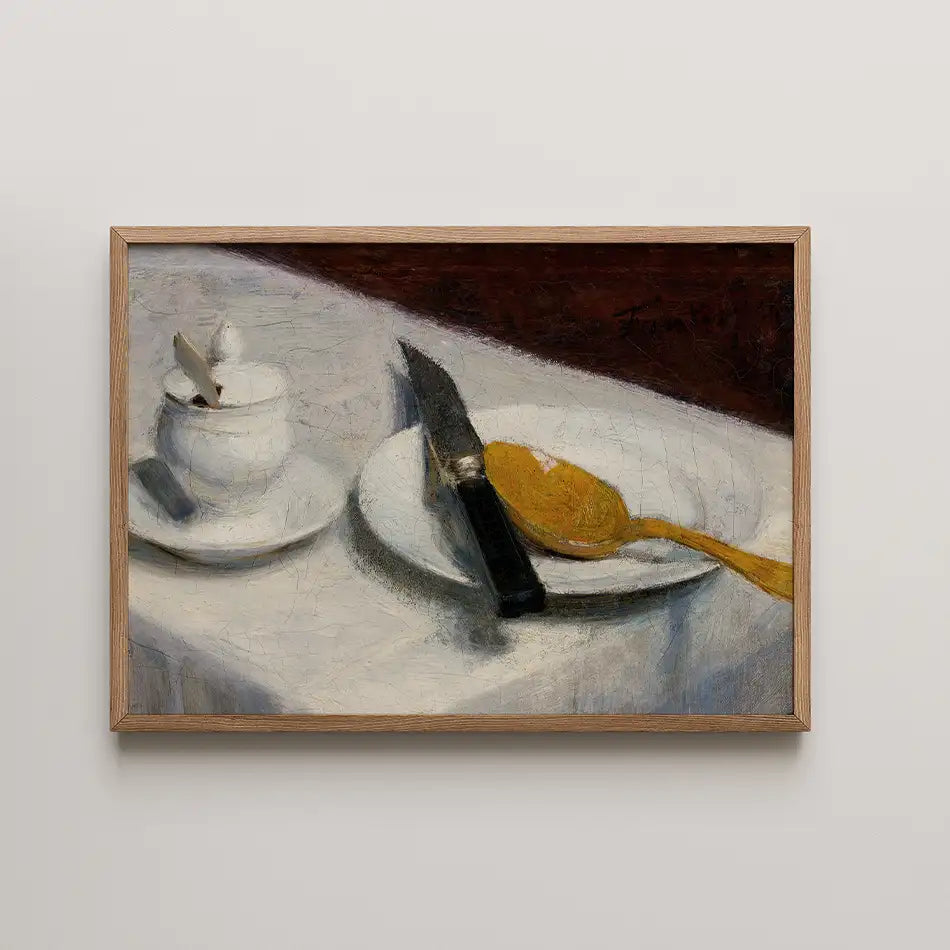 Still life painting featuring a table setting with a white cup, a plate with a yellow spoon, and a knife, framed in wood.