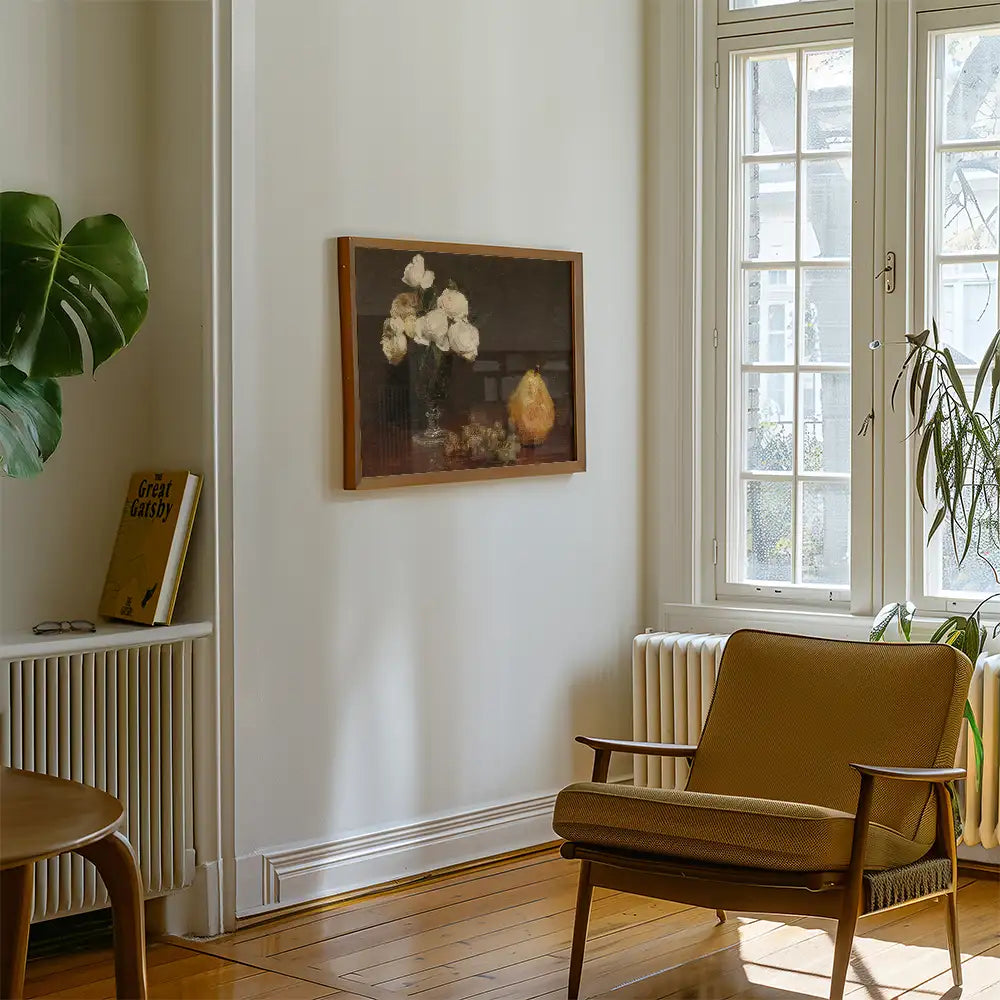 Modern interior featuring a framed painting of white flowers and a pear, with a cozy armchair and bookshelf in a well-lit room.