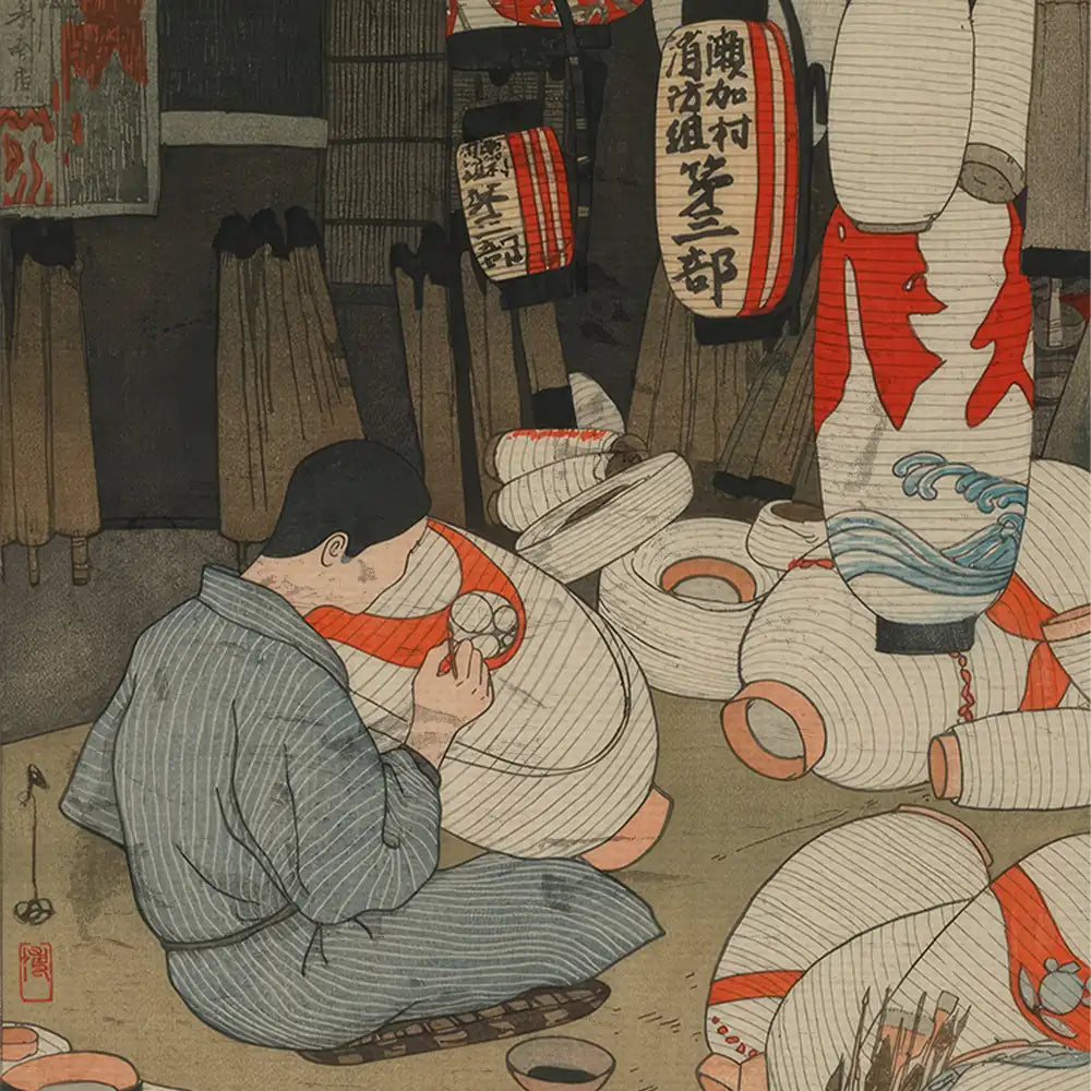 A person in traditional clothing carefully paints a red design on a white lantern surrounded by more decorative lanterns and tools in a workshop setting.