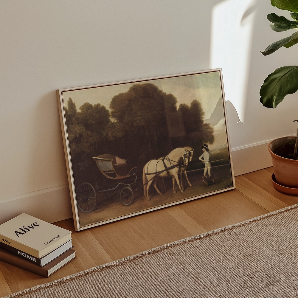 Framed vintage painting of a horse and carriage with a person on a path surrounded by trees, leaning against a wall in a modern interior setting.